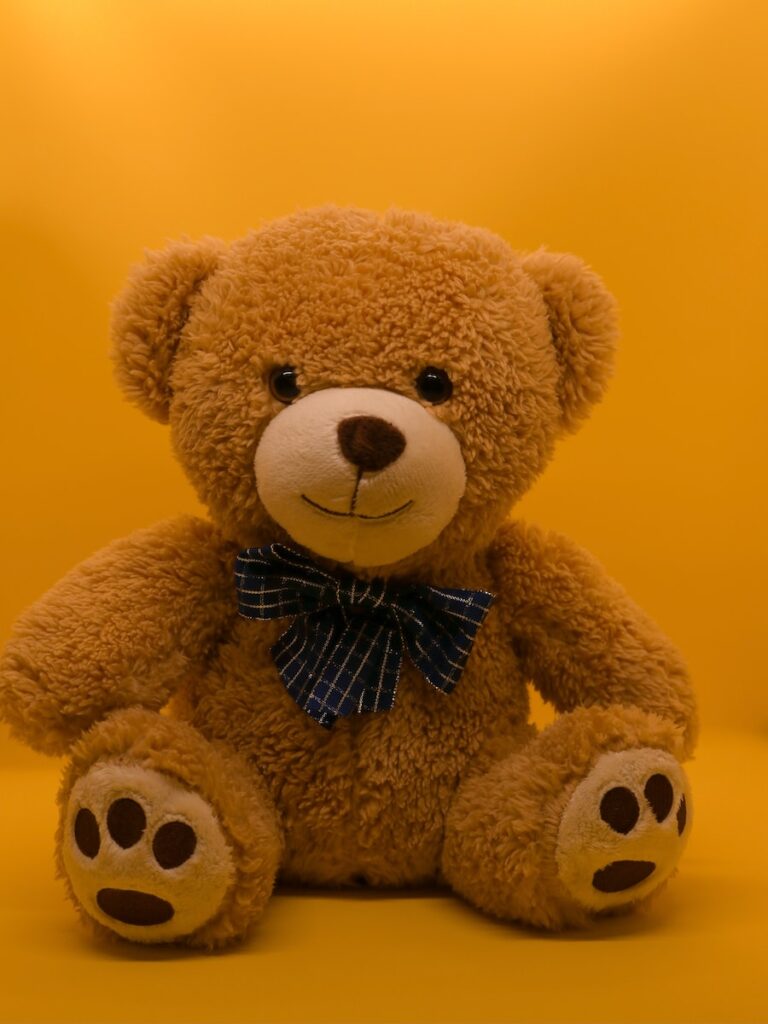 brown teddy bear with black and white bow tie